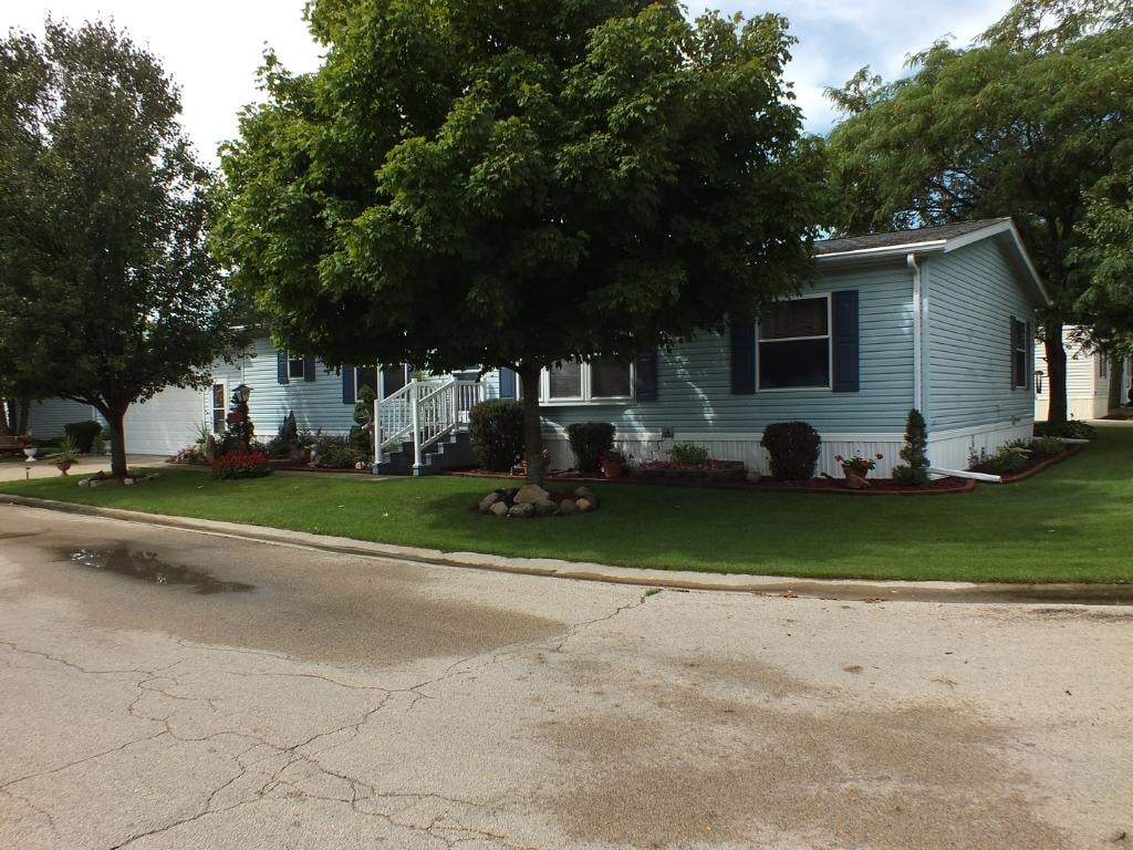 Double wide home with arbor and landscaping at Knollwood Estates
