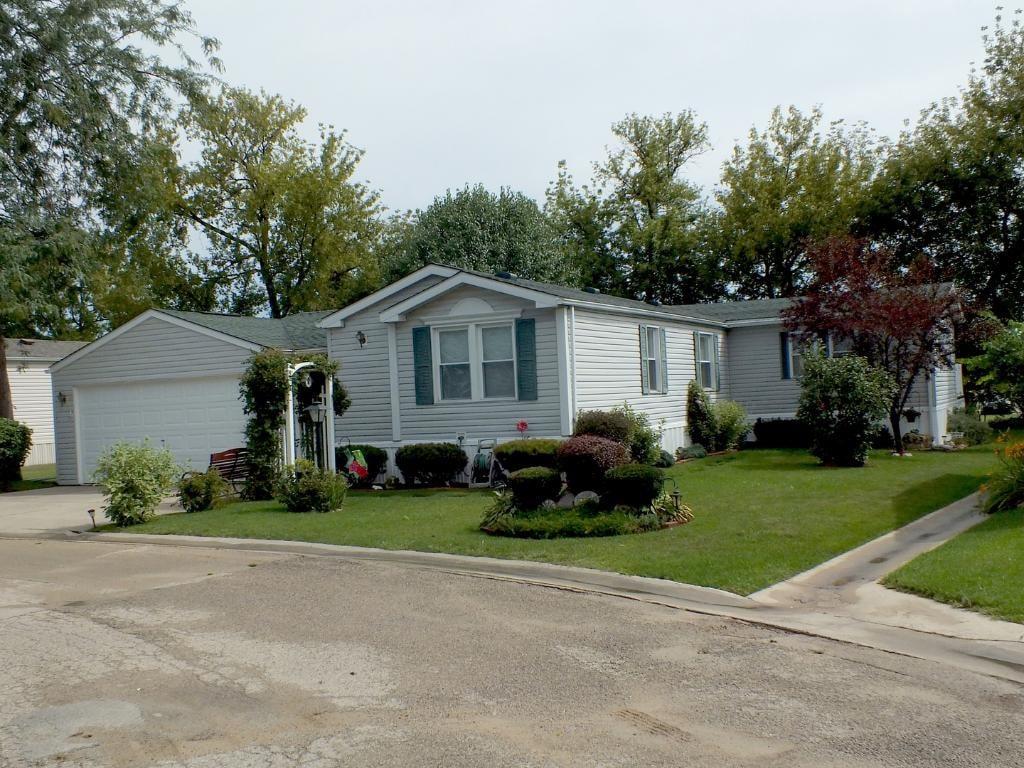 Tan double wide home with two-car garage at Knollwood Estates